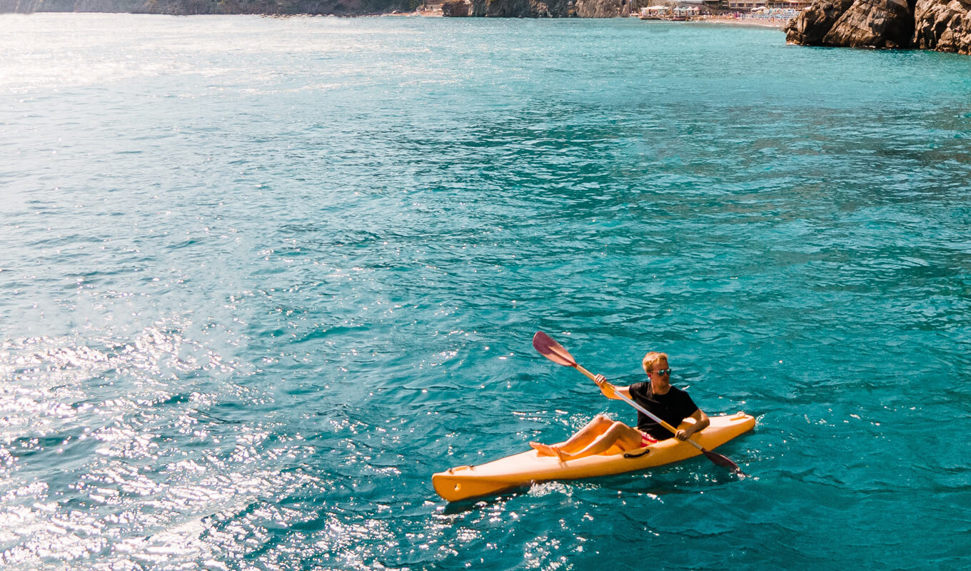 Man on a red shirt using yellow sit on top kayak