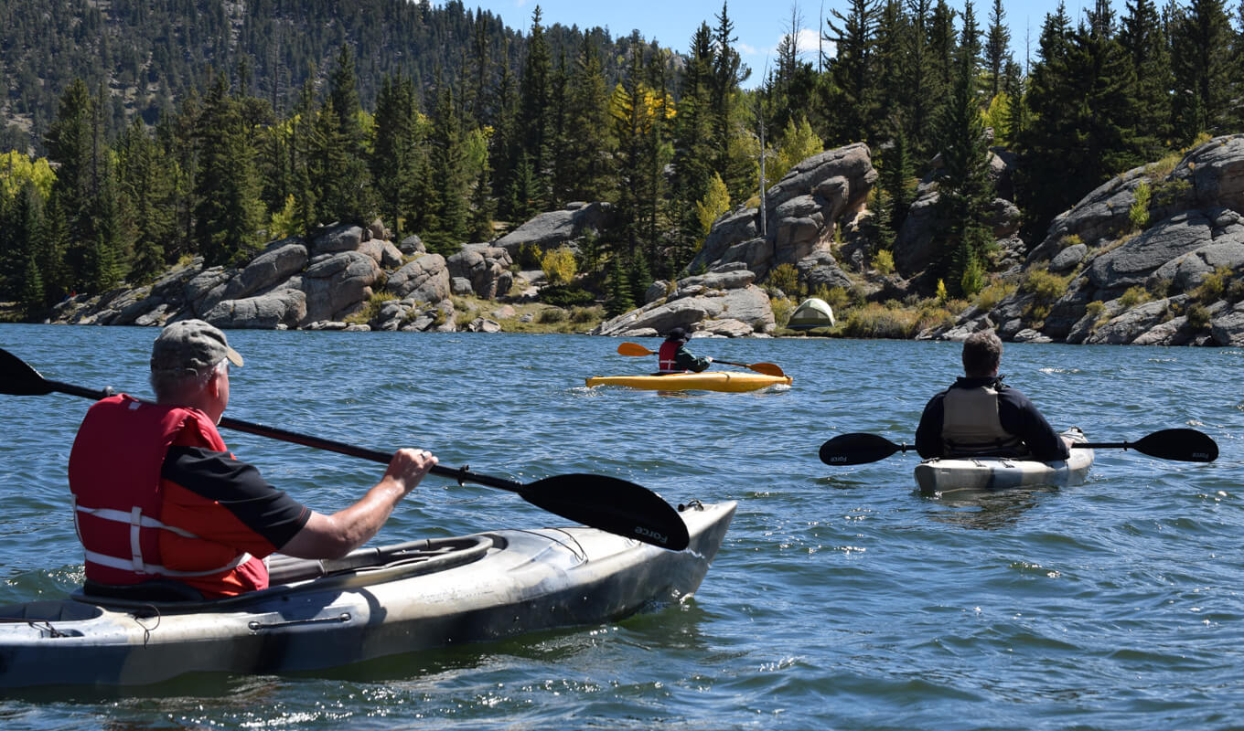 Three men riding kayaks