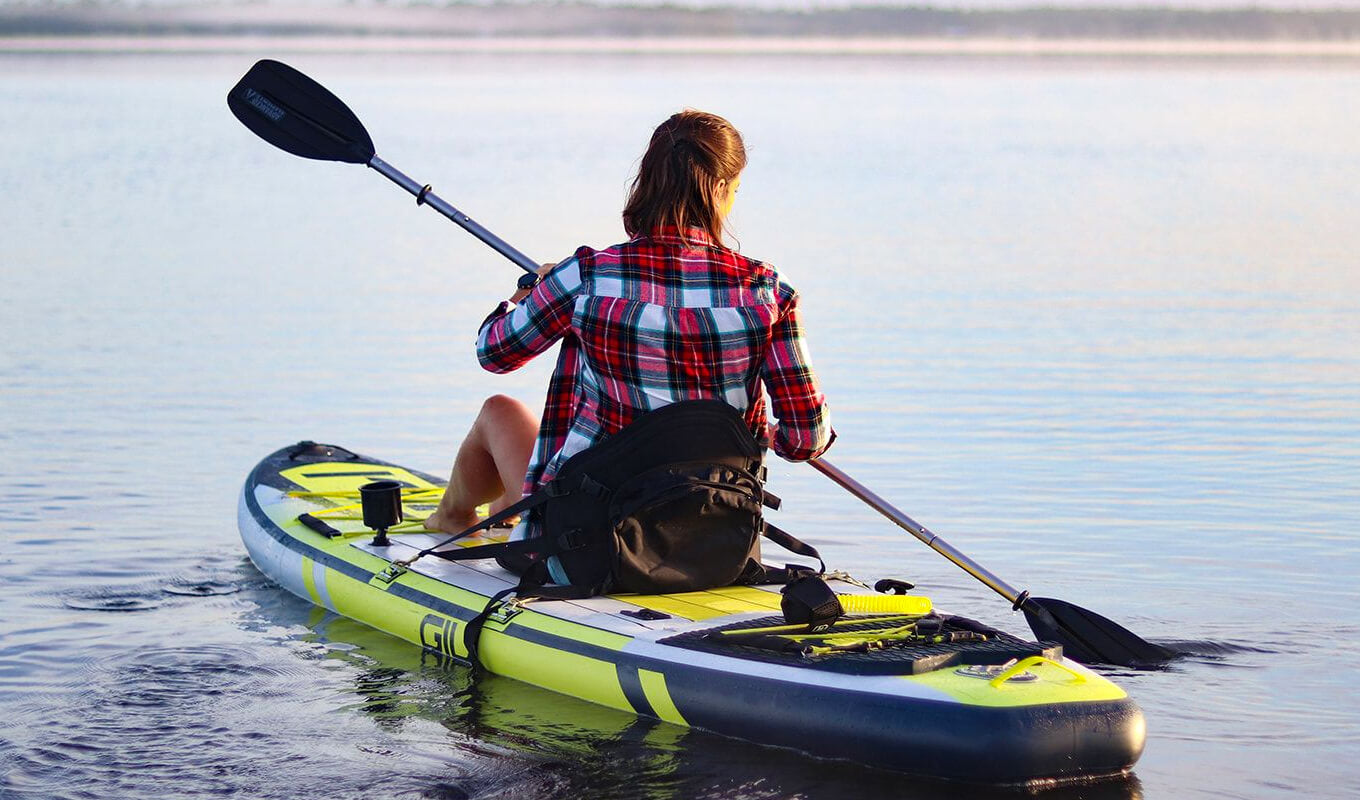 Woman on a converted kayak inflatable paddle board