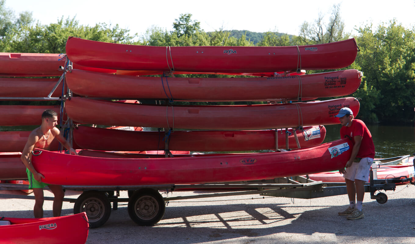 Two man carrying a red kayak