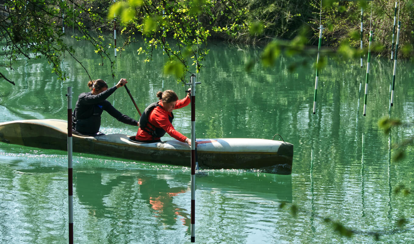 Two women riding on a black gray sit inside tandem kayak