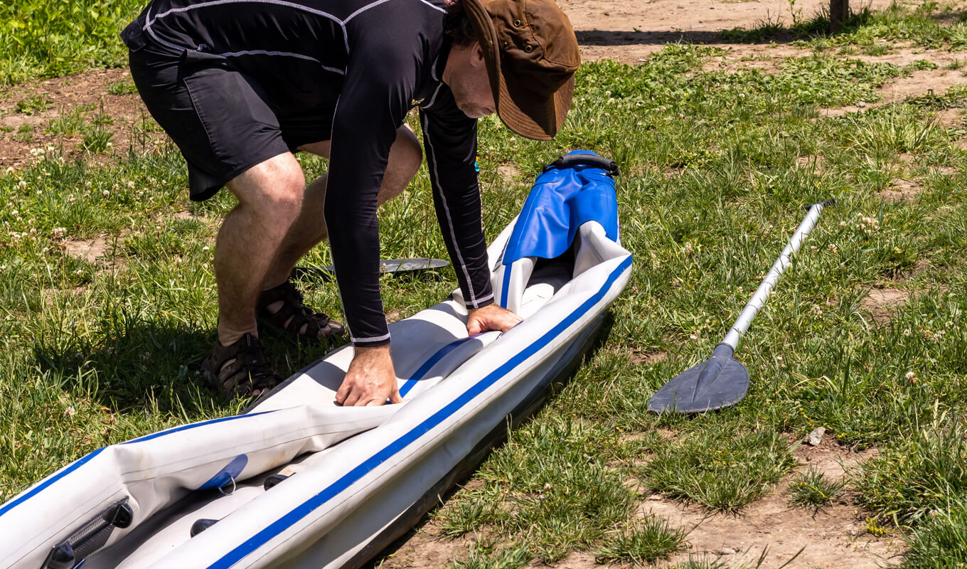 Man deflating an inflatable kayak